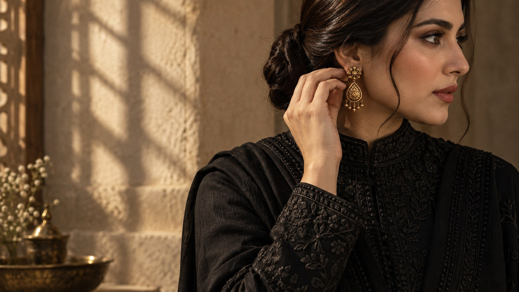 Gold earring styled with a high-neck black embroidered Pakistani outfit